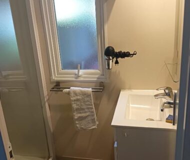 Salle de bains avec lavabo fenêtre et serviette au camping Le HAVRE DU MEN DU