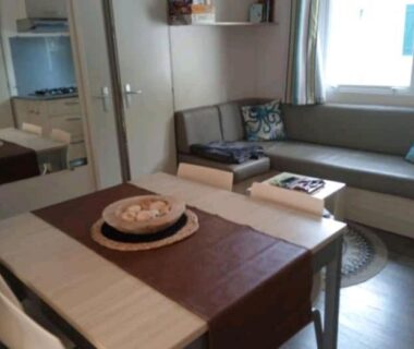 Salon avec canapé et table à manger dans le logement Le Kraken