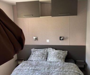 Chambre avec lit double et rangements au camping Le Lac des Rêves