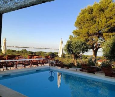 Piscine et terrasse avec vue sur le lac au camping Le Lac des Rêves