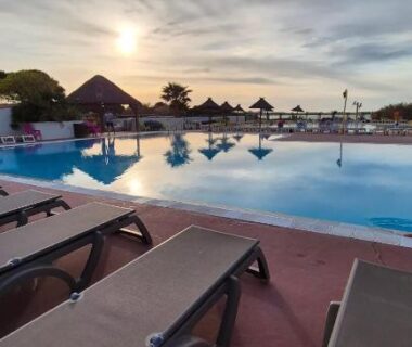 Bord de la piscine avec transats au camping Le Lac des Rêves