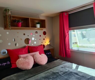 Chambre avec lit double et coussins roses dans le bungalow Le Lagon Rose Camping SIBLU Le Mar Estang