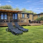 Pelouse avec transats devant la terrasse du Mobil Home Le Lounge