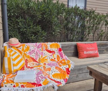 Terrasse en bois avec serviette et chapeau au Lounge Mobil Home