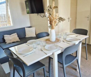 Coin repas table dressée canapé dans le Lounge Mobil Home à 200 m de la plage Les Dunes