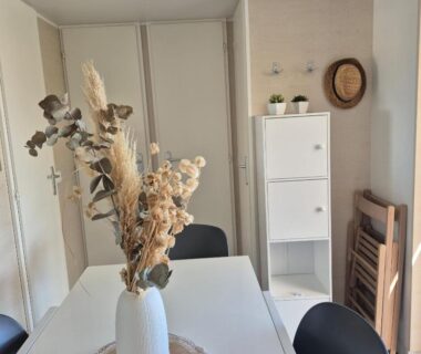Coin repas avec table et bouquet sec dans le mobil home Le Lounge Mobil Home