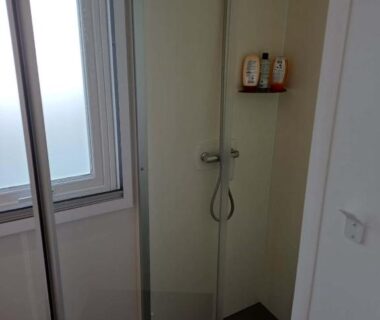 Salle de douche avec cabine vitrée et fenêtre dans le Mobilhome Douillet climatisé 5 pers