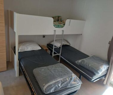 Chambre avec lits simples et lit superposé dans Le Mobilhome Douillet climatisé 5 pers en camping