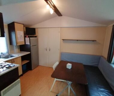 Coin salon avec kitchenette dans le mobil-home Le Moulin du Pont D'Aliès