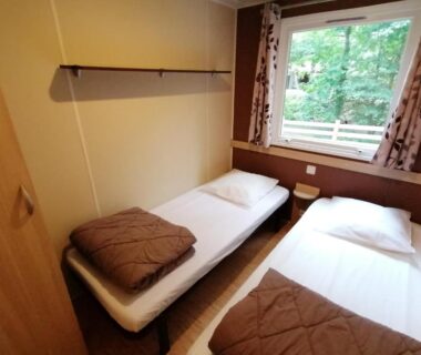 Chambre avec deux lits et fenêtre au camping Le Moulin du Pont D'Aliès