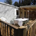 Terrasse en bois avec table et chaises au camping Le Muscat
