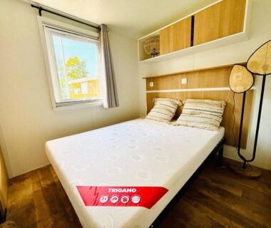 Chambre avec lit double et fenêtre dans le bungalow Le Nid des Viviers