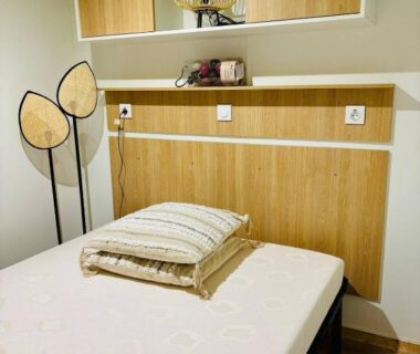 Chambre avec lit tête de lit en bois et ventilateur dans le bungalow Le Nid des Viviers