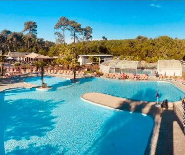 Piscine extérieure avec transats au camping Le Nid des Viviers bungalow au bord de l'eau