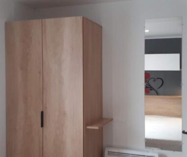 Intérieur avec armoire miroir radiateur et rideau dans l'hébergement Le Panorama