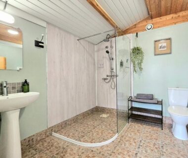 Salle de bain avec douche à l'italienne lavabo et WC dans l'hébergement Le Ranch Camping et Glamping