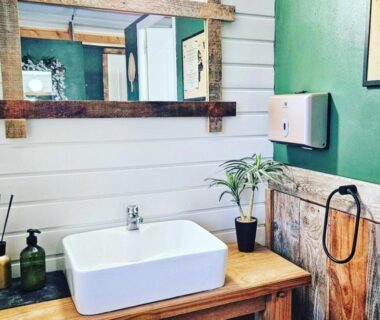 Salle de bain avec lavabo sur meuble en bois dans Le Ranch Camping et Glamping