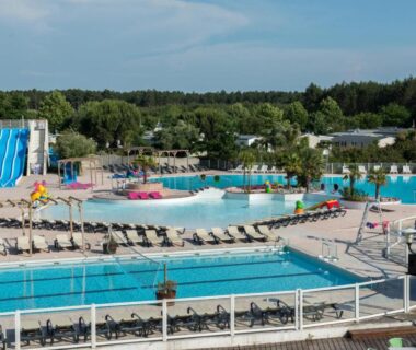 Piscine extérieure avec toboggans et transats au camping Le Rêve bleu MOBIL HOME 49 3 CHAMBRES