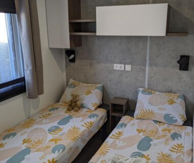 Chambre avec deux lits simples et fenêtre dans le mobil home Le Rêve bleu MOBIL HOME 49 3 CHAMBRES