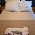 Chambre intérieure avec lit double oreillers et serviettes dans Le Ried Camping To hapi