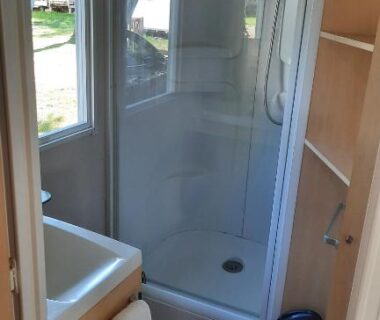 Salle d'eau avec cabine de douche et lavabo dans le mobil-home Le Ried Camping To hapi