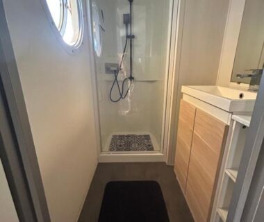 Salle d'eau avec cabine de douche et lavabo dans le logement Le SaraLéna