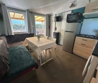 Intérieur de mobil-home avec coin repas et kitchenette au camping Le SaraLéna