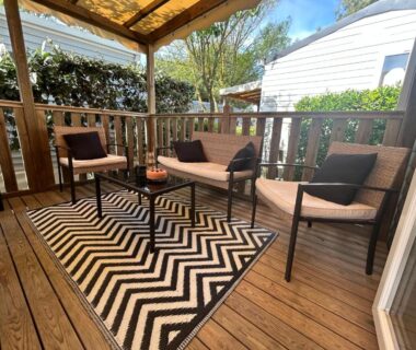 Terrasse couverte avec fauteuils table et tapis du mobil-home Le SaraLéna