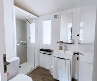 Salle de bain avec douche et toilettes dans Le Ti Buch Mobilhome