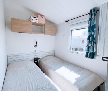 Chambre lumineuse avec deux lits simples dans le mobilhome Le Ti Buch