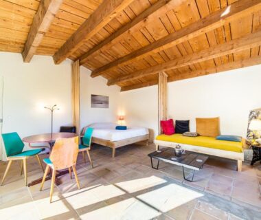 Intérieur de chambre avec lit et coin salon dans le camping Le Travers Ajoux - Camping Gîte Évènement