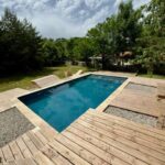 Piscine rectangulaire et terrasse en bois au Camping Le Travers Ajoux