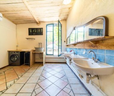 Laverie lumineuse avec lavabos et miroir dans le gîte Le Travers Ajoux
