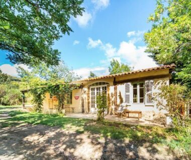 Façade du gîte en pierre dans un jardin ombragé au camping Le Travers Ajoux Gîte Évènement