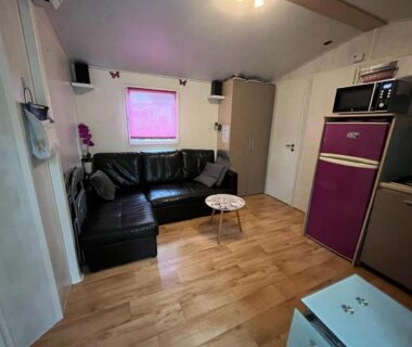 Coin salon avec canapé d'angle et kitchenette dans l'hébergement Le TropeZen Confort Plus TV WIFI VOD PISCINE CHAUFEE