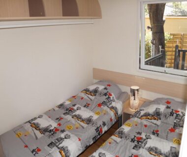 Chambre avec deux lits et lampe dans Le TropeZen Confort Plus TV WIFI VOD PISCINE CHAUFEE