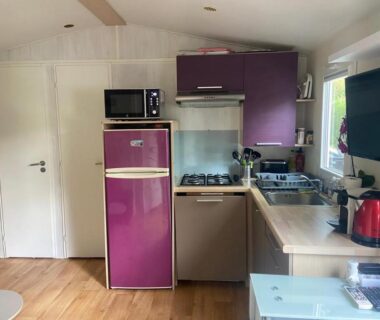 Kitchenette avec réfrigérateur violet évier et TV dans le mobil-home Le TropeZen Confort Plus TV WIFI VOD PISCINE CHAUFEE