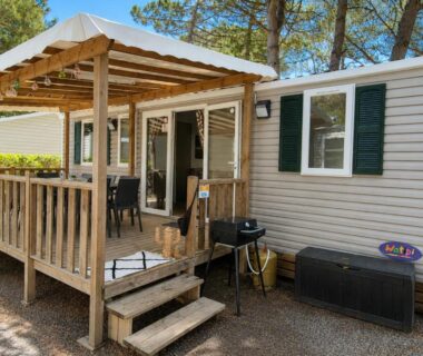 Terrasse en bois devant mobil-home avec barbecue au camping Le Zéphyr