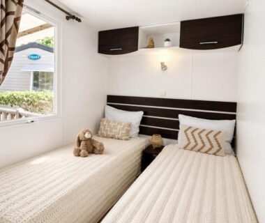 Chambre avec deux lits simples et peluches dans le mobile home au camping Le Zéphyr