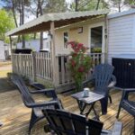 Terrasse en bois avec fauteuils et table au camping Le balaou