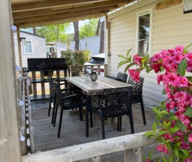 Terrasse en bois avec table et chaises du camping Le Balaou