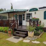 Terrasse en bois et jardinières sur pelouse du mobilhome Le beau mobilhome