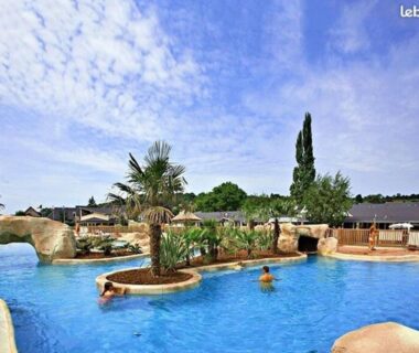 Piscine extérieure avec îlots et palmiers au camping Le beau mobilhome