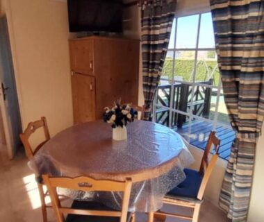 Intérieur coin repas et kitchenette avec terrasse du mobilhome Le beau mobilhome
