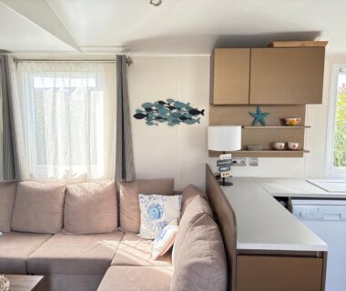 Intérieur avec canapé d'angle et kitchenette dans Le cabanon