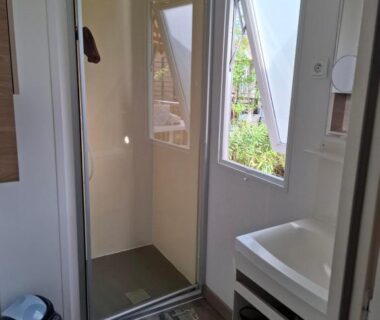Salle de bain avec douche cabine et lavabo dans Le lac des reves escapade 66
