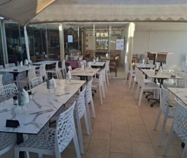 Terrasse couverte avec tables et chaises au camping Le lac des reves escapade 66
