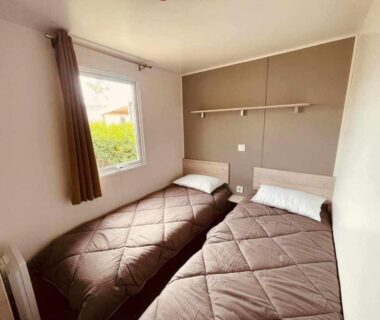 Chambre avec deux lits simples et fenêtre dans l'hébergement Le paradis du sud