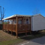 Terrasse couverte en bois et mobil home dans le camping Le paradis du sud