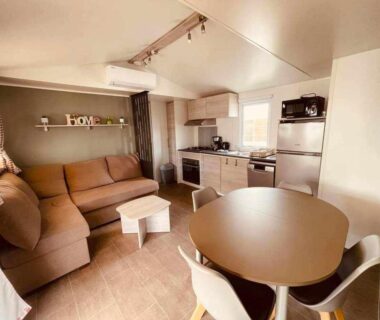 Intérieur avec salon kitchenette et table à manger du mobil-home Le paradis du sud